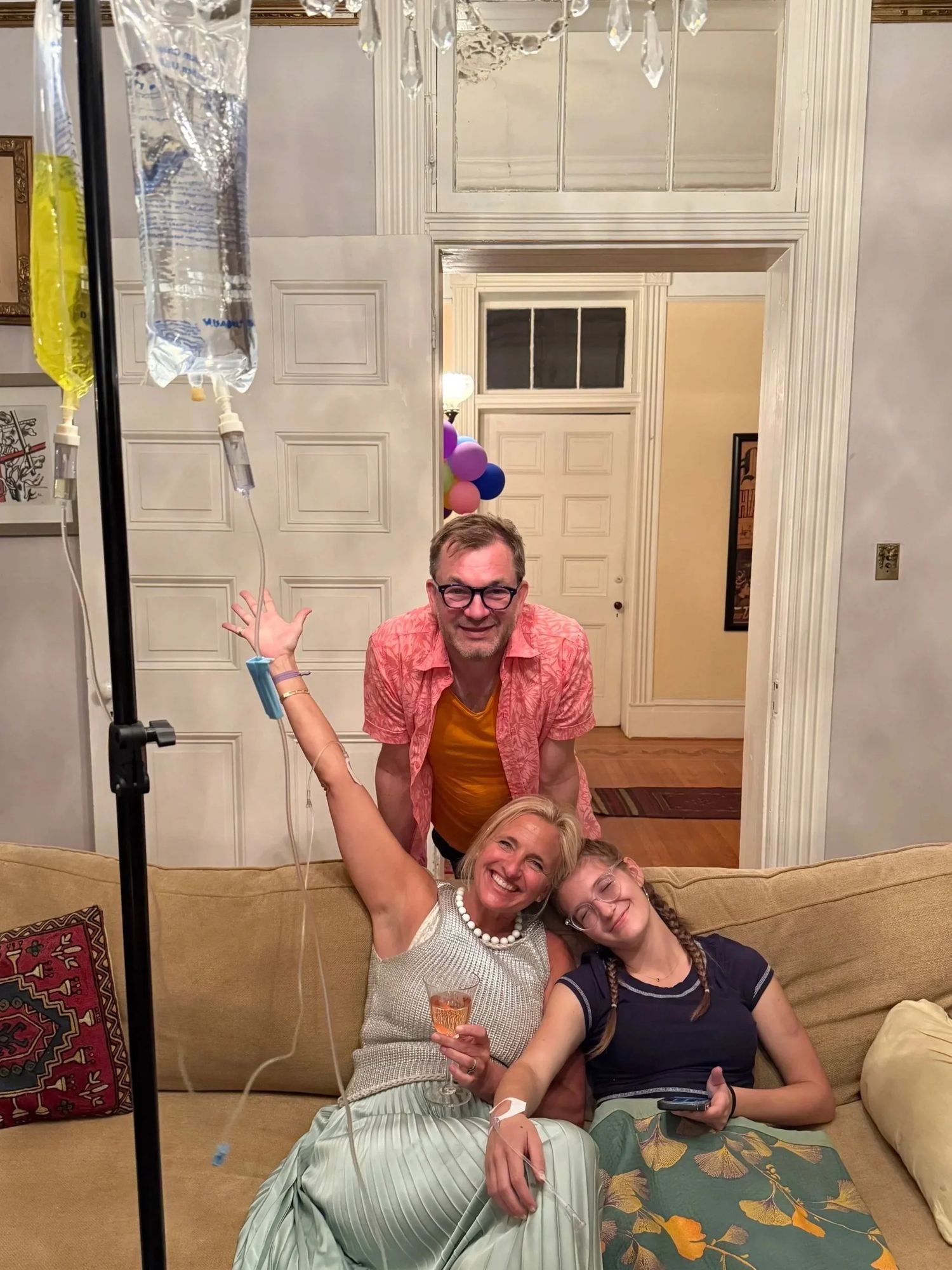 A family receiving IV therapy together in their living room